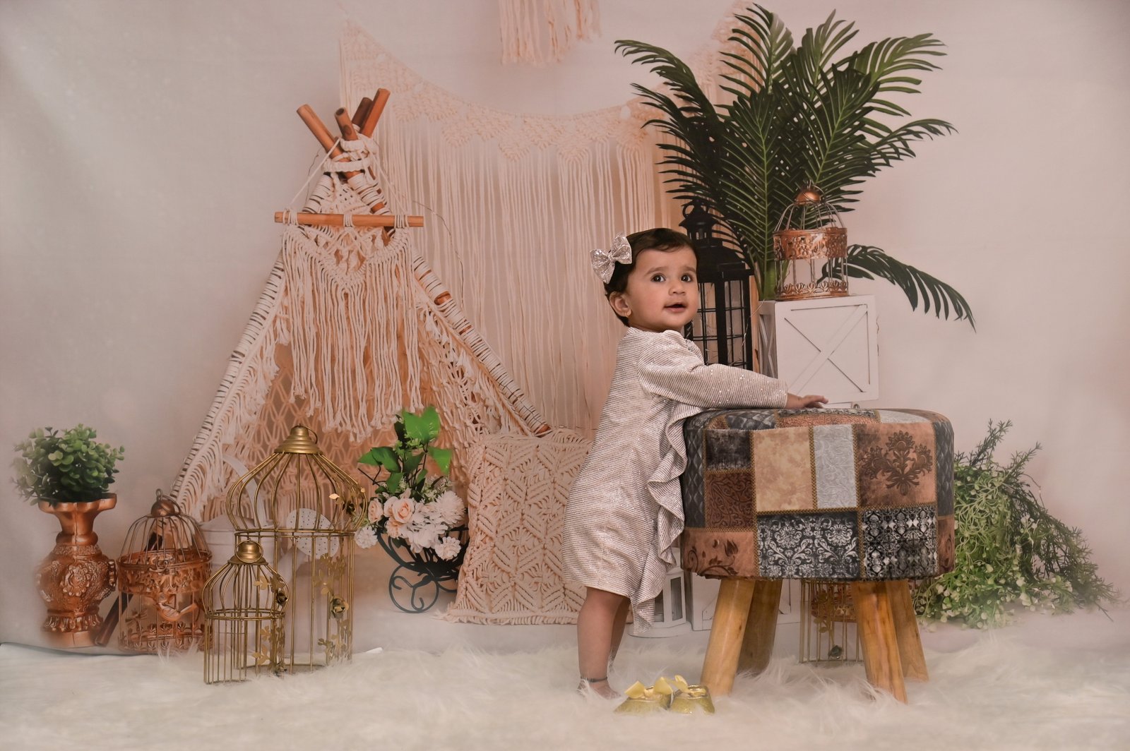 Baby standing among elegant bohemian studio props
